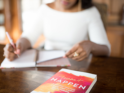 A woman sitting at a table with an open book.